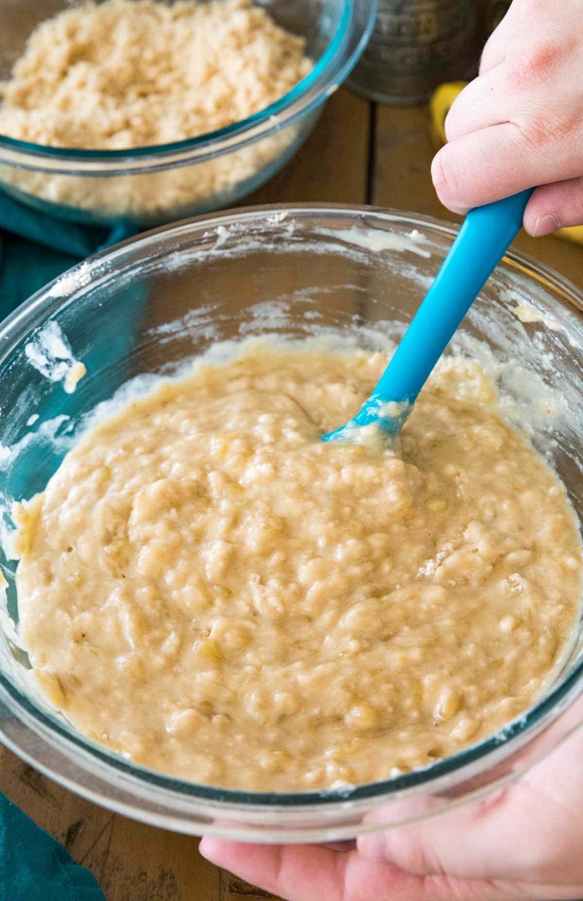 muffin batter being stirred with a blue rubber spatula