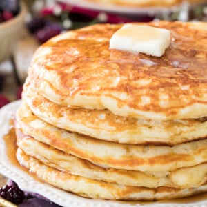 buttermilk pancakes on white plate with butter