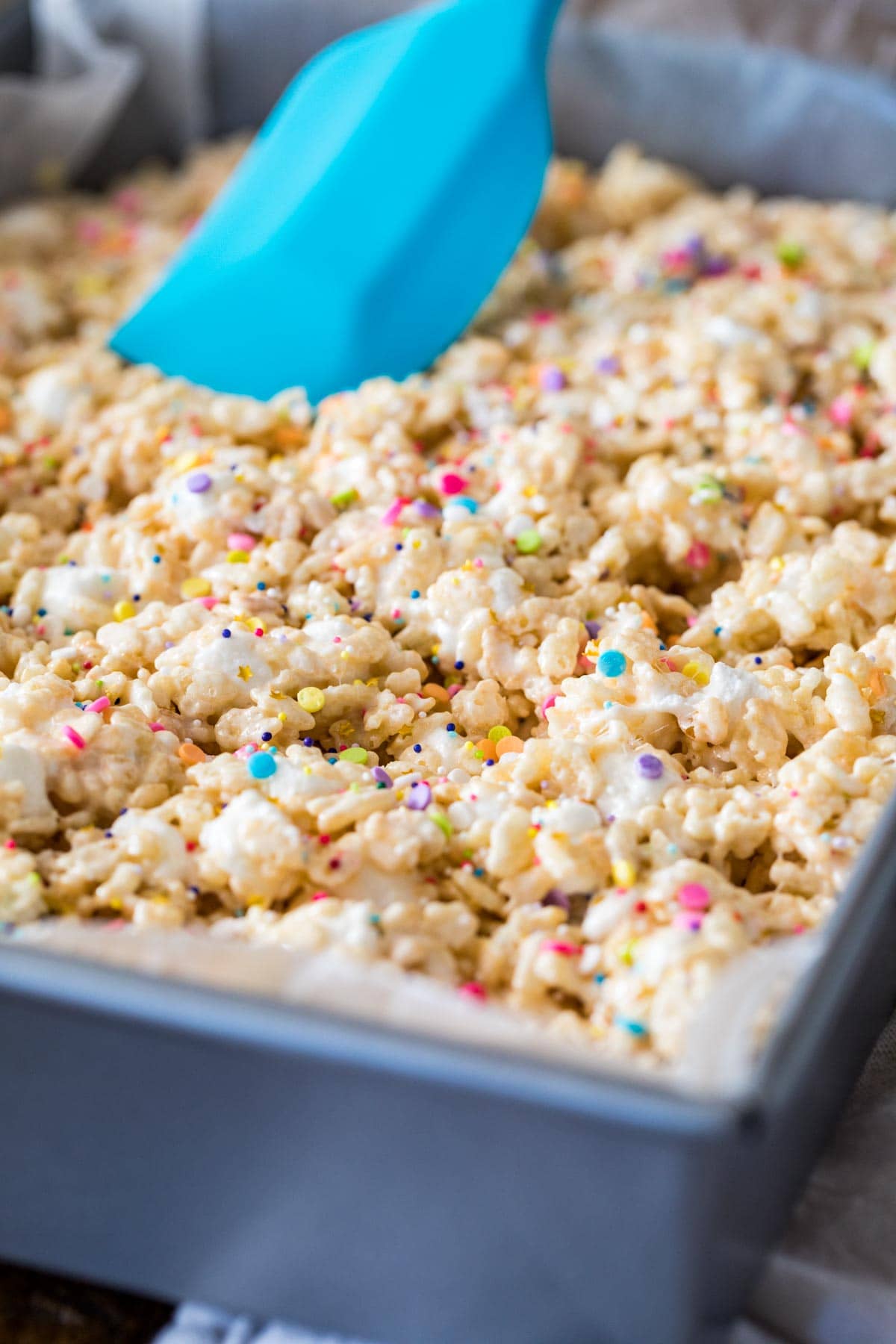 Spreading the mixture into the pan with a spatula.