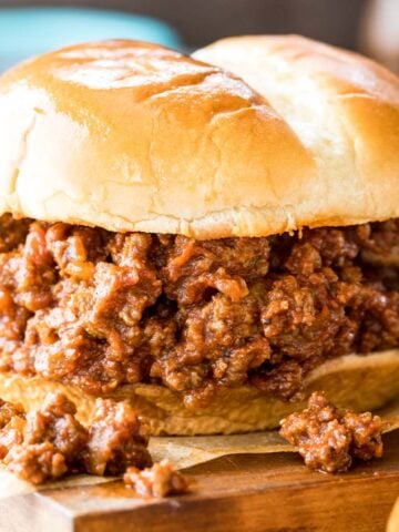 sloppy joe sandwich resting on a wood cutting board