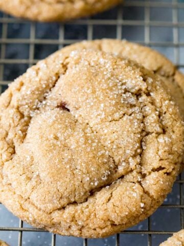 Sparkly brown sugar cookies with crackled tops on a metal cooling rack.