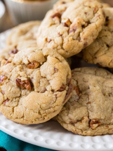 Butter pecan cookies piled onto a white plate.