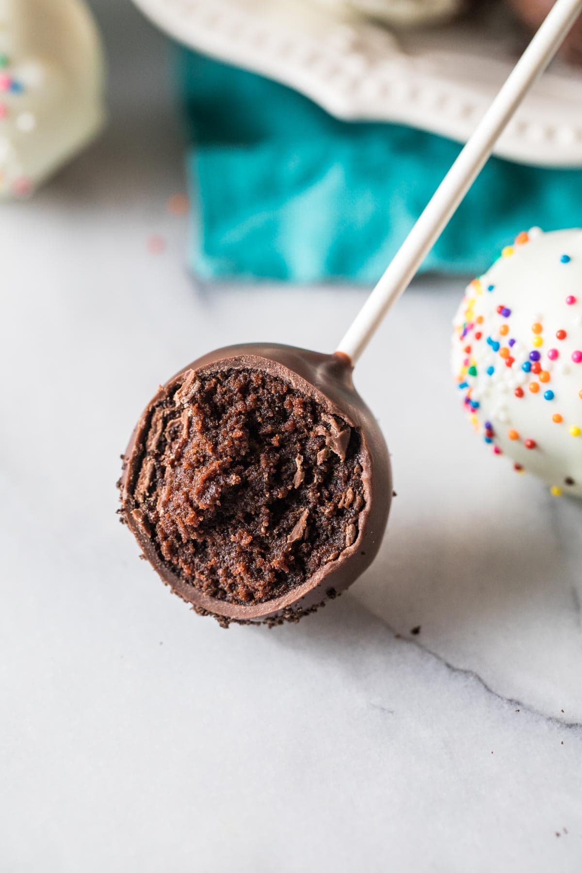 Close-up view of a cake pop made with chocolate cake coated in dark chocolate.