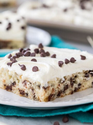 slice of chocolate chip sheet cake on a white plate on a teal towel