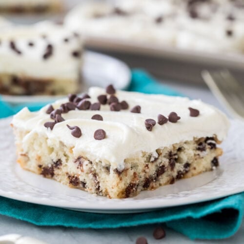 slice of chocolate chip sheet cake on a white plate on a teal towel