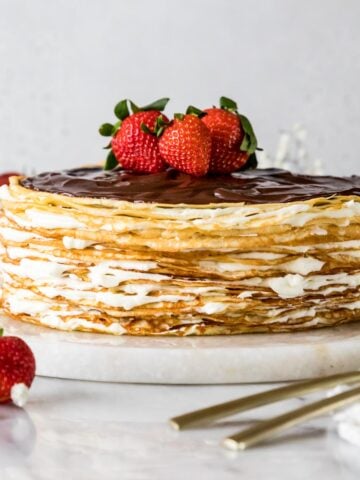 Crepe cake topped with chocolate ganache and fresh strawberries.