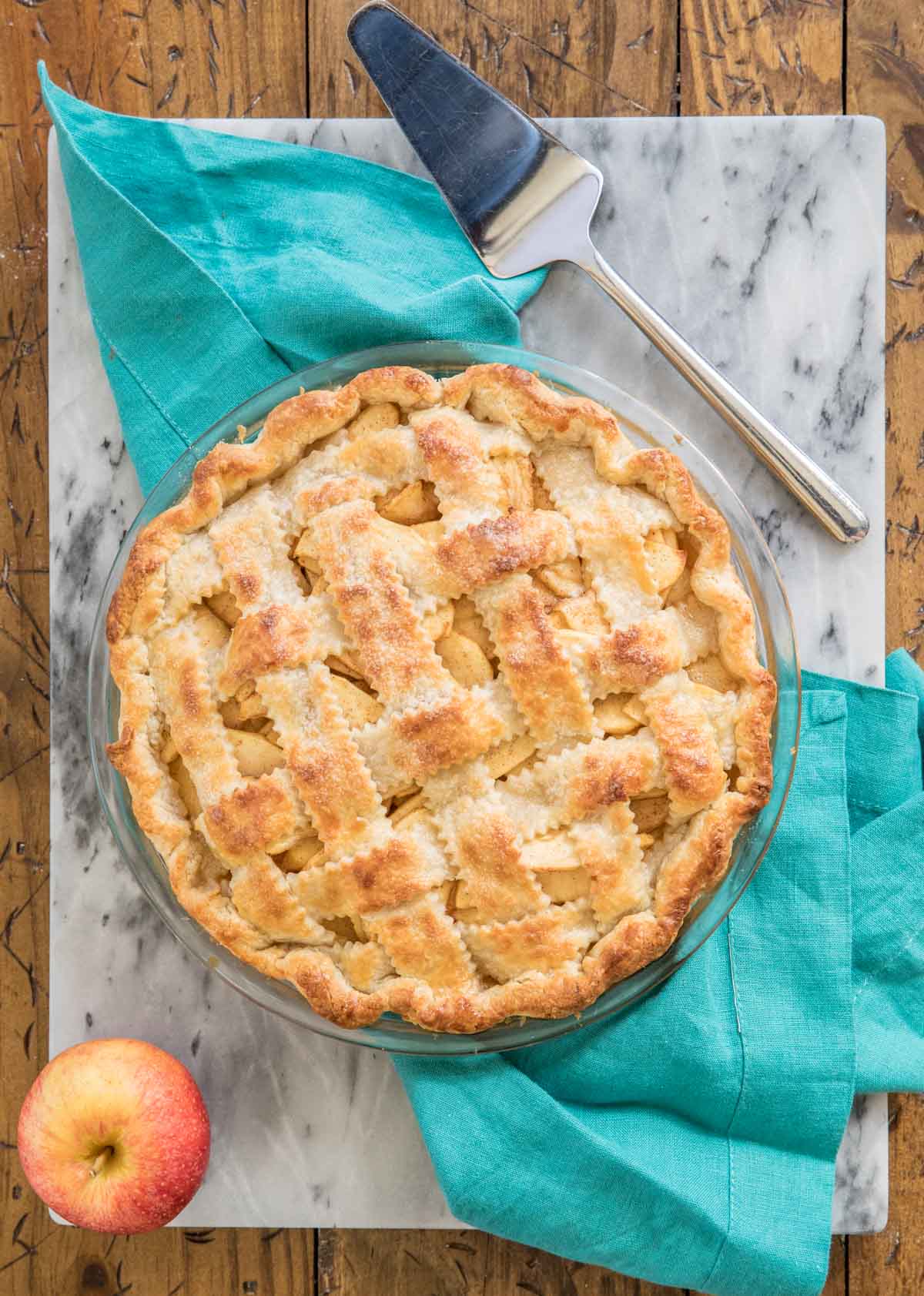 lattice pie made with homemade pie crust resting on turquoise towel