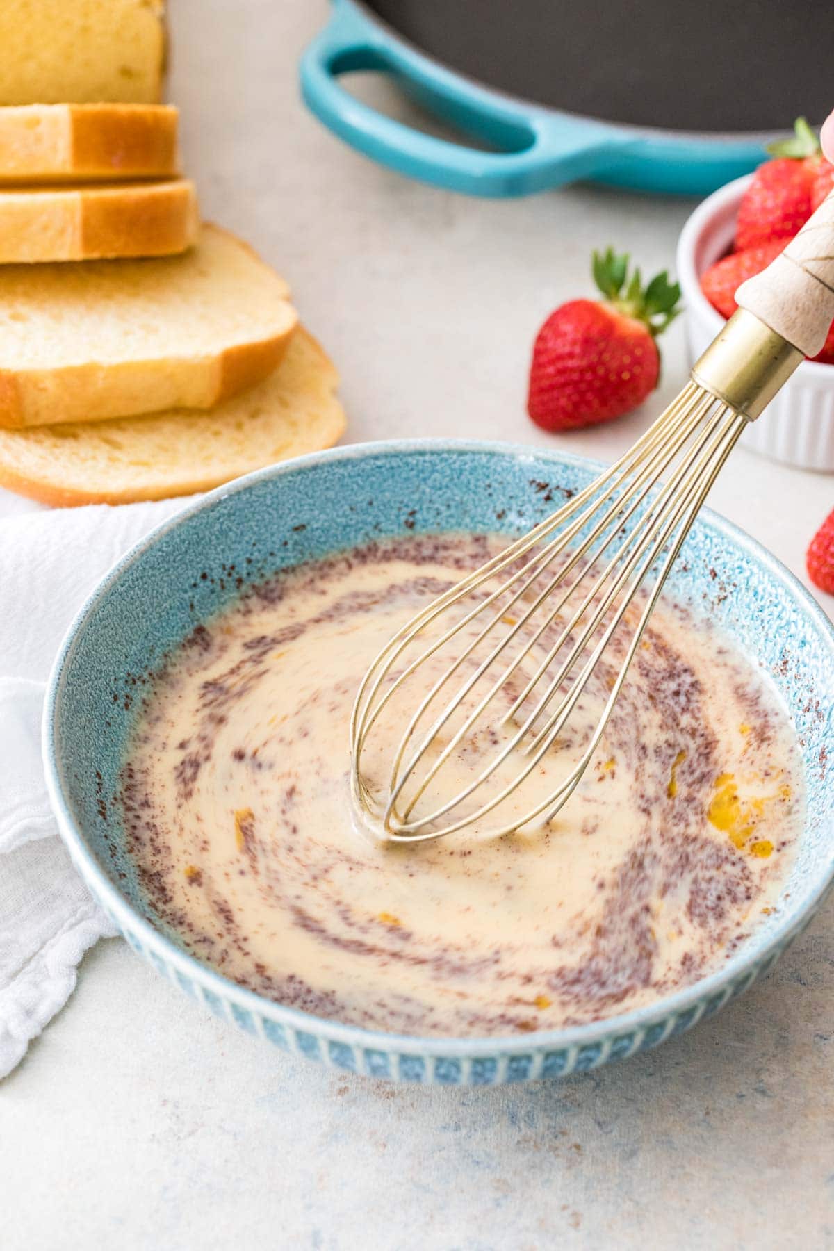 Whisk mixing a cinnamon custard mixture together.