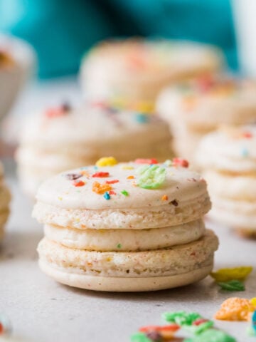 Fruity pebble macarons on a white countertop.