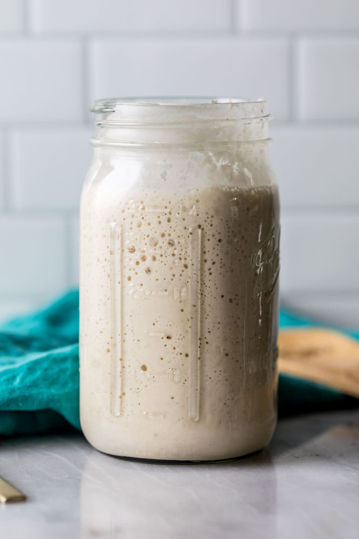 Large glass jar of sourdough starter.