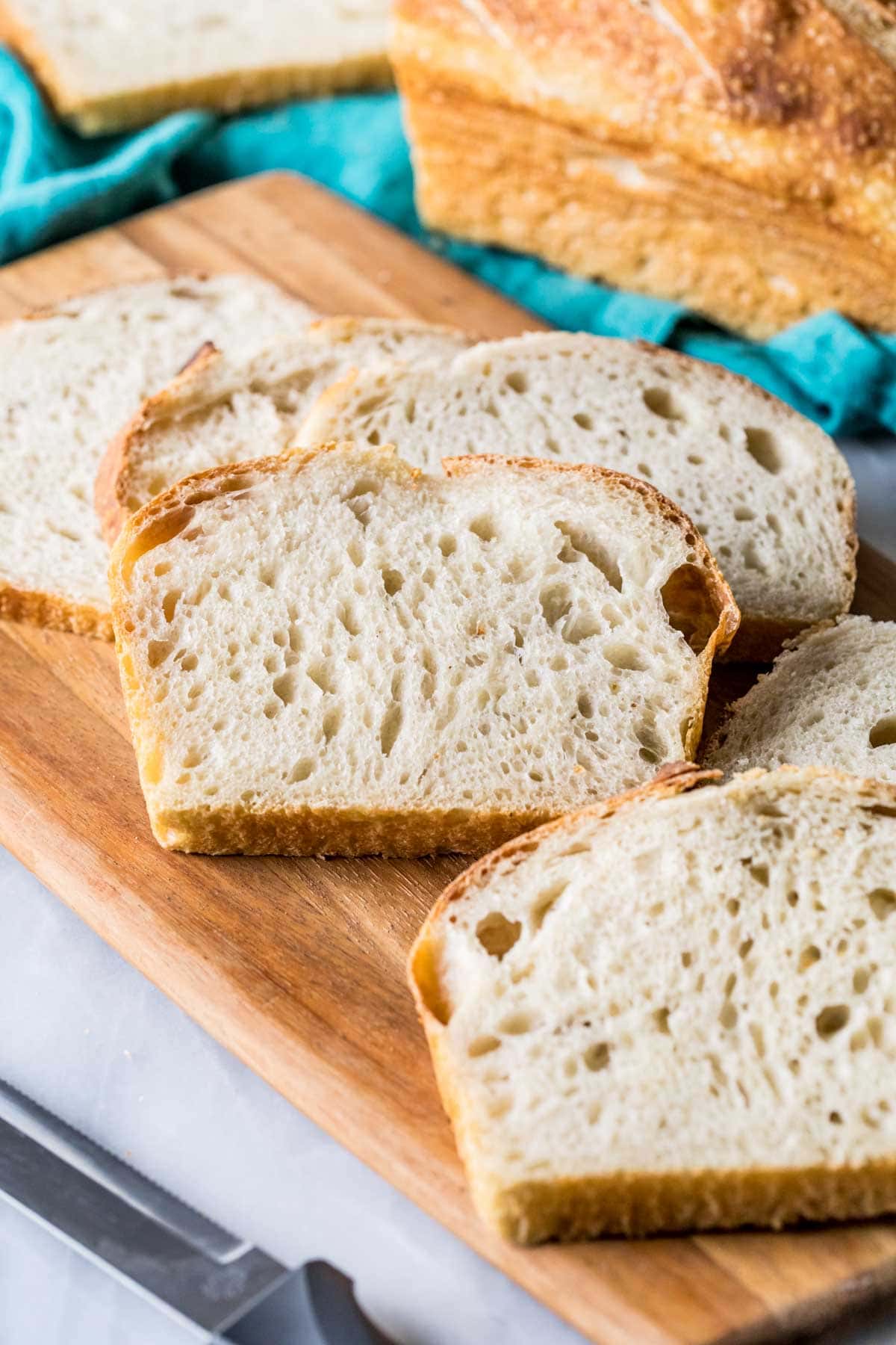 Slices of sourdough bread on a wood cutting board.