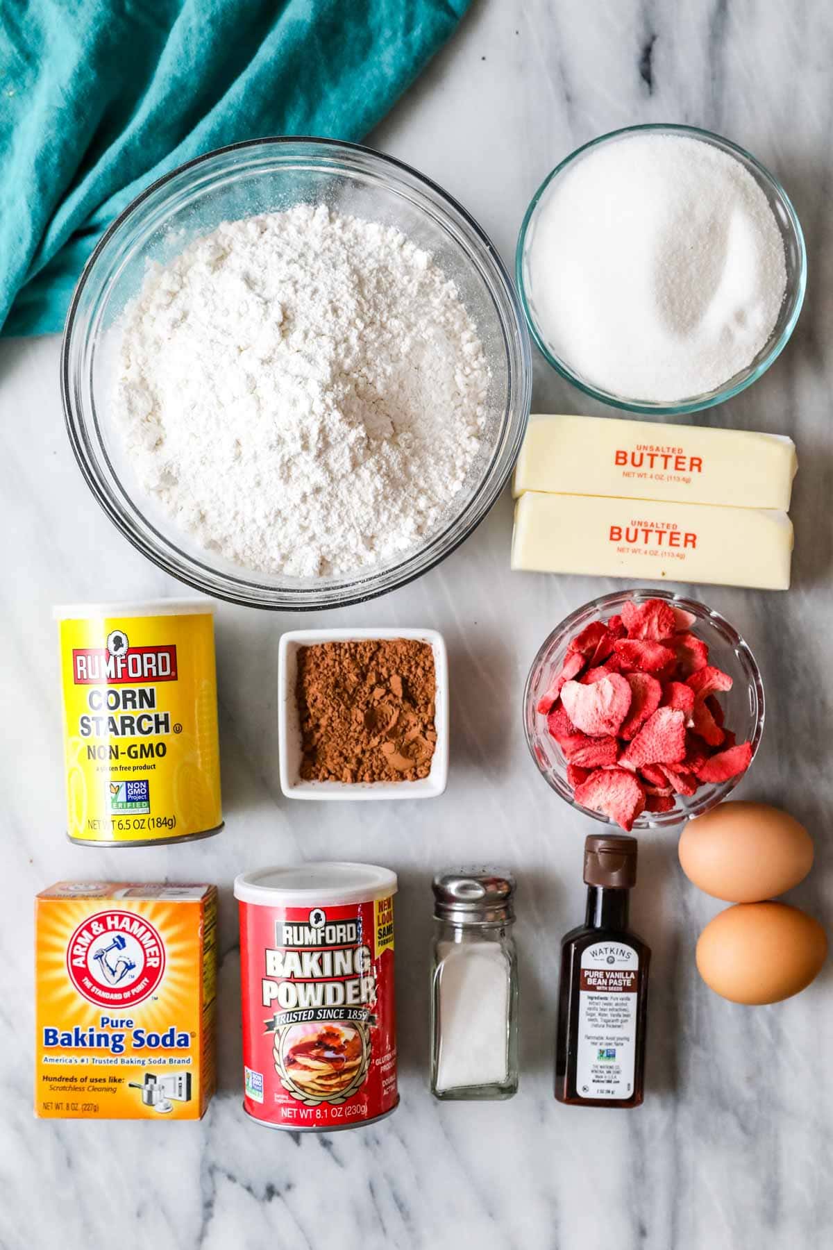 Overhead view of ingredients including cocoa powder, freeze dried strawberries, corn starch, and more.