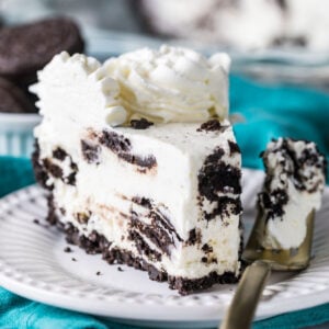 Slice of Oreo pie on a plate with a fork beside it holding the first bite.