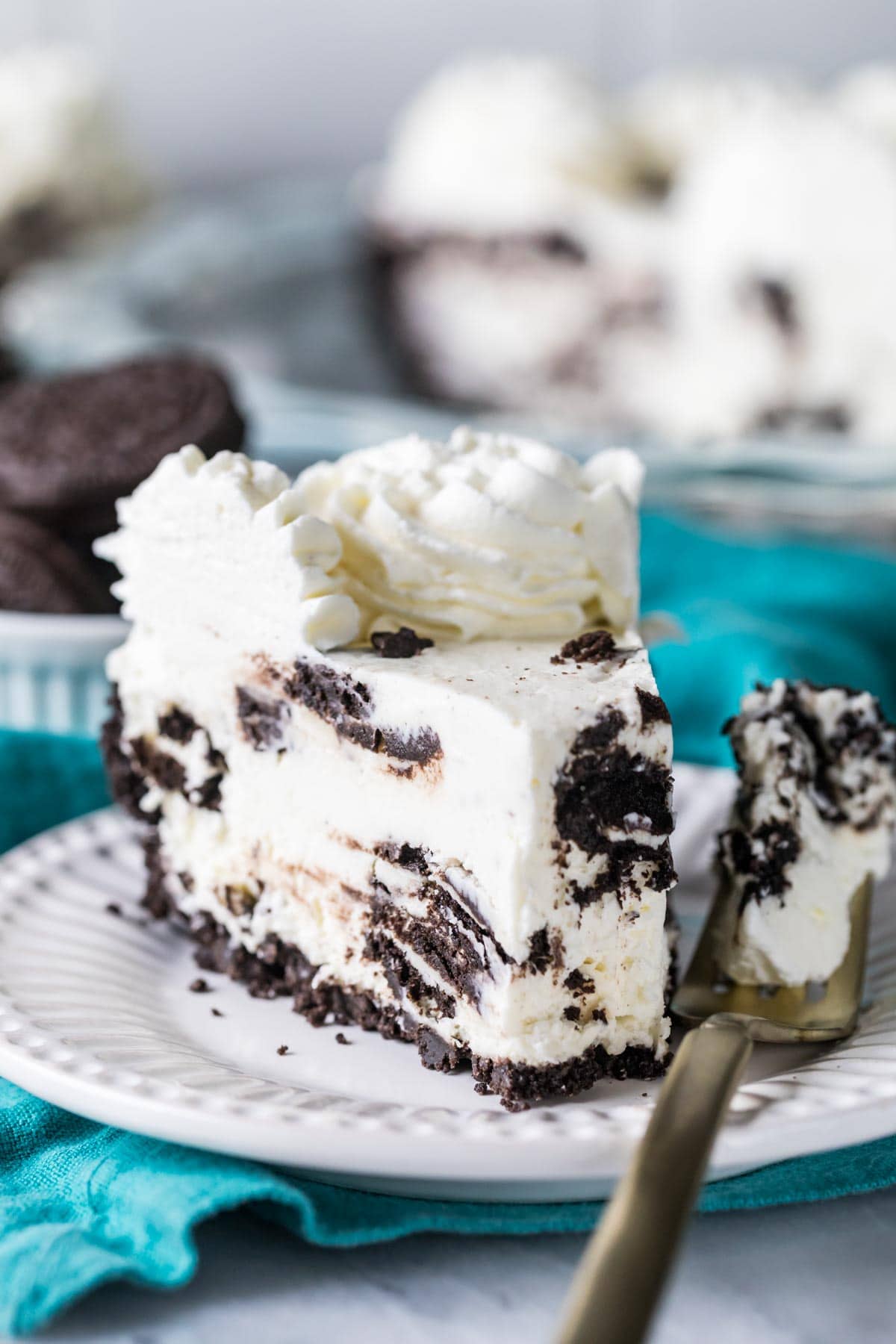 Slice of Oreo pie on a plate with a fork beside it holding the first bite.