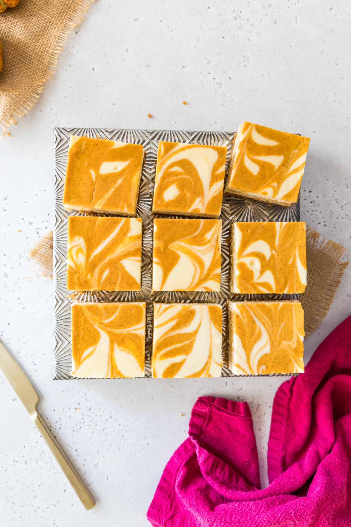 Overhead view of swirled pumpkin cheesecake bars just after cutting.