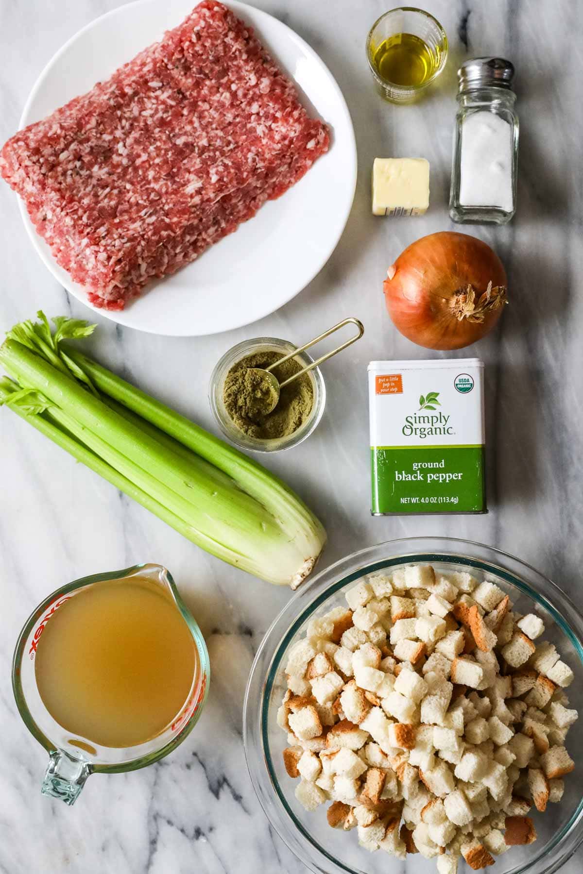 Overhead view of ingredients including Italian sausage, celery, and dried bread cubes.