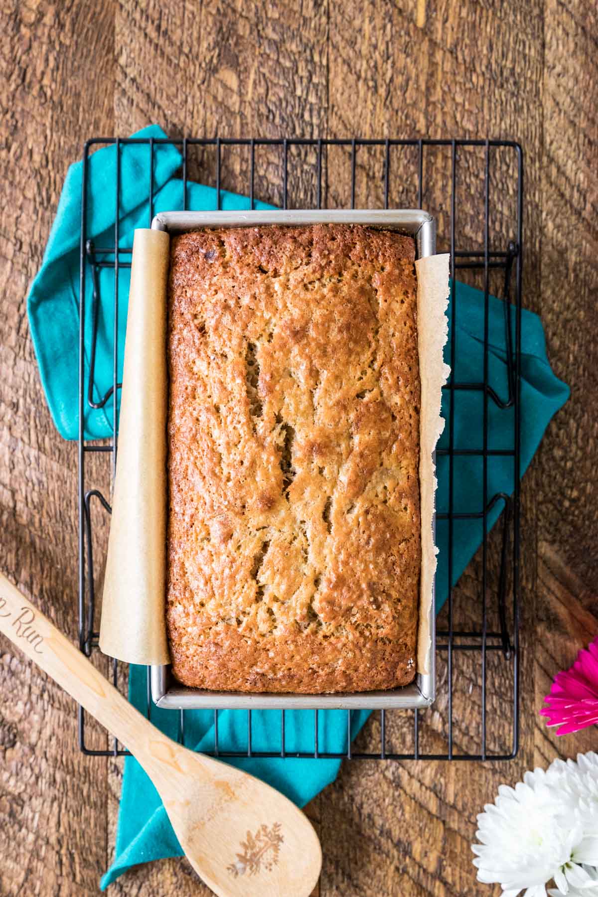 Overhead view of a loaf of banana bread made with sourdough discard in a bread pan on a cooling rack.