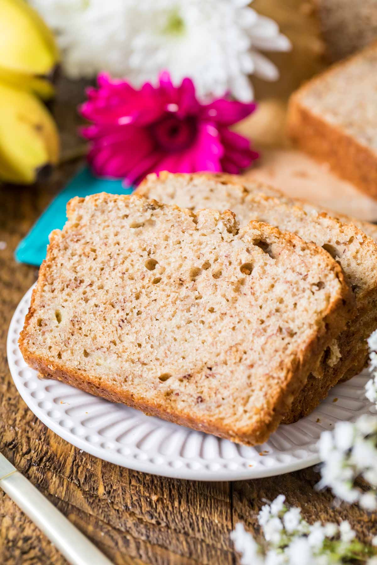 Slices of banana bread made with sourdough discard on a white plate.