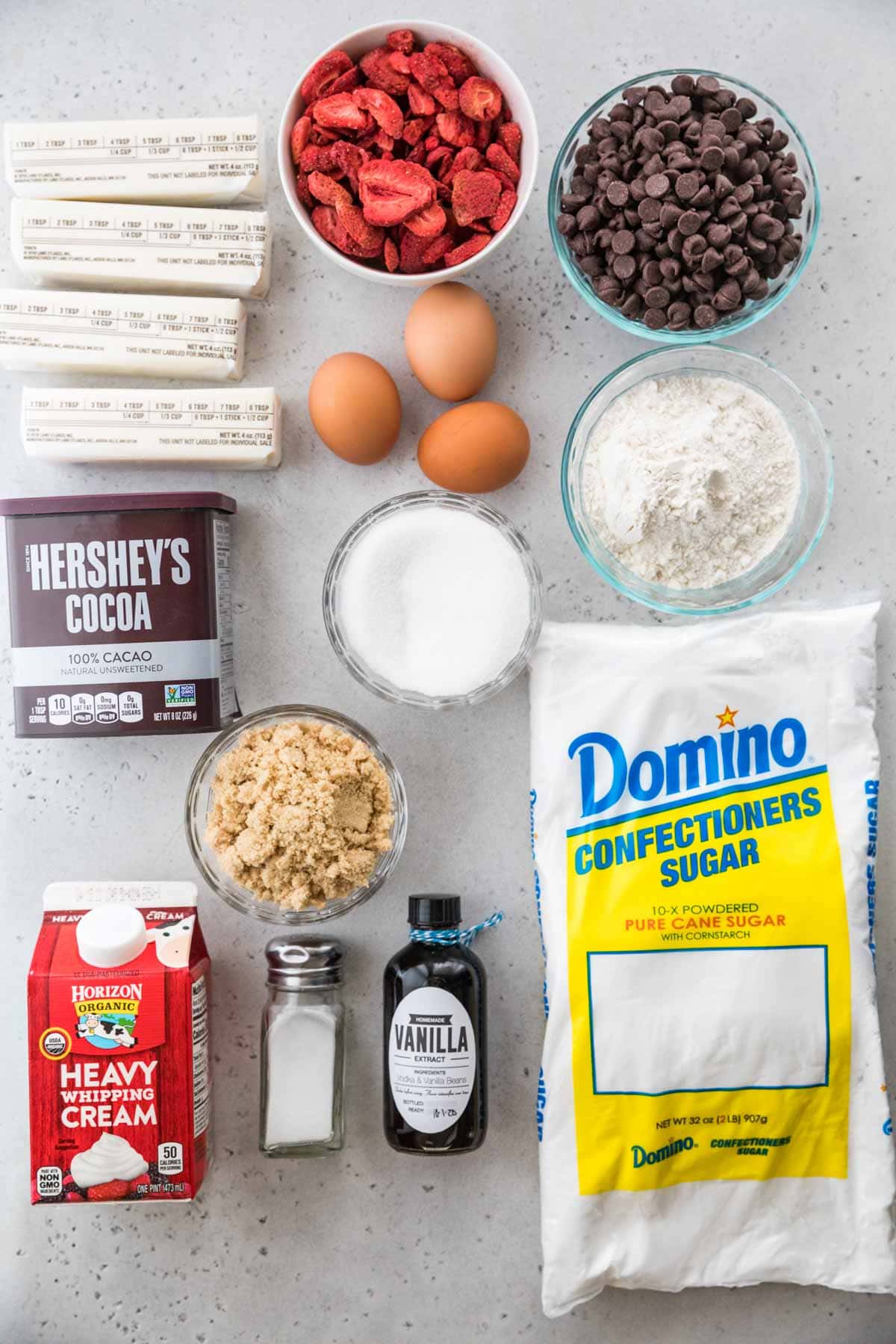 overhead view of ingredients including freeze-dried strawberries, chocolate chips, butter, cocoa powder, and more