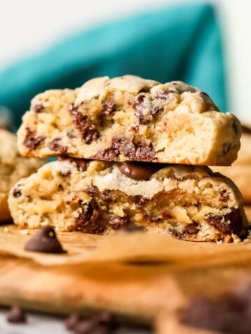 Two halves of thick chocolate chip cookies stacked on top of each other.